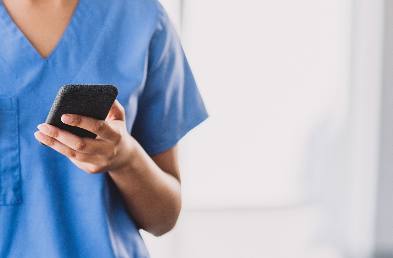 A dental professional with a phone in hand